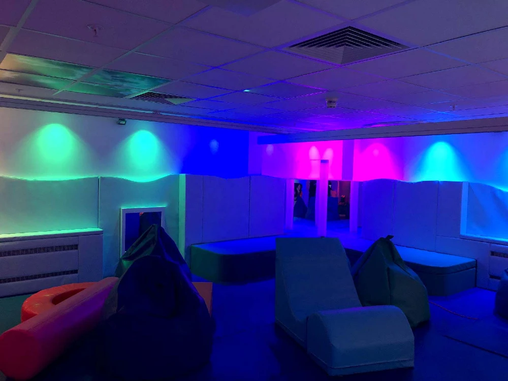 Supported living sensory room with soft lighting, cushions, and sensory equipment for adults